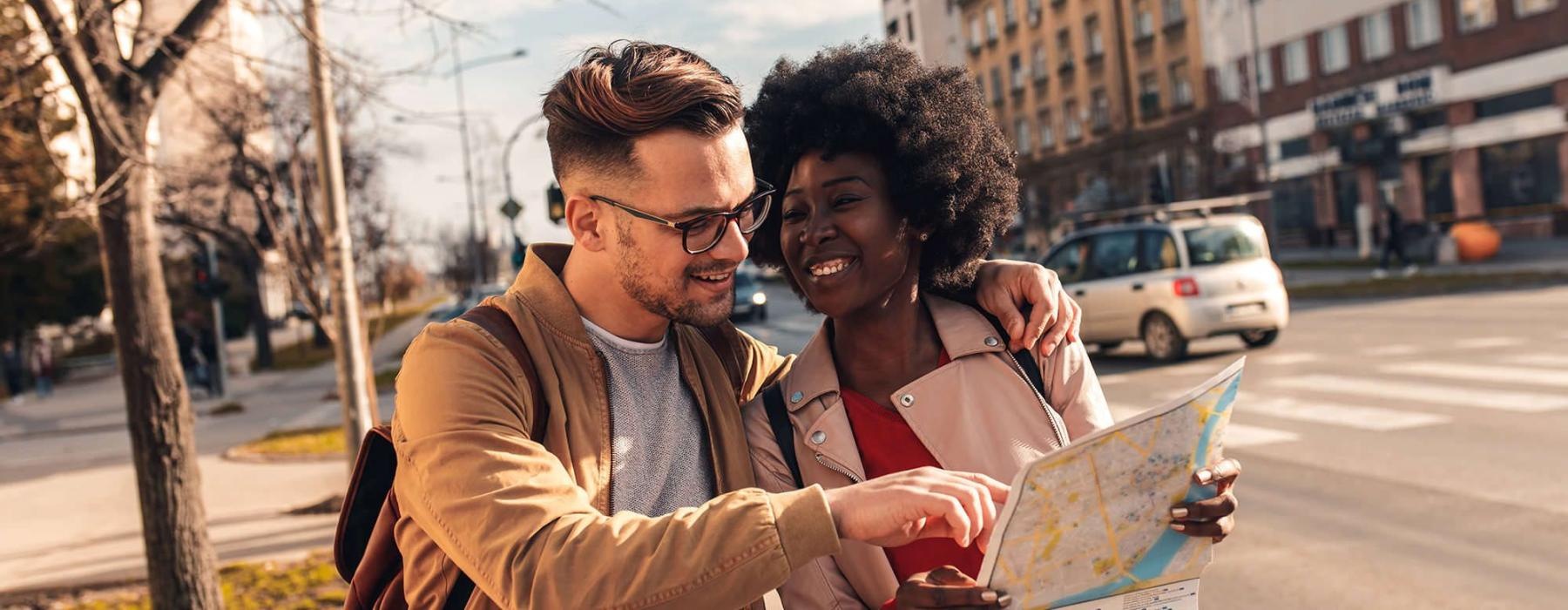 a man and woman looking at a map in the city